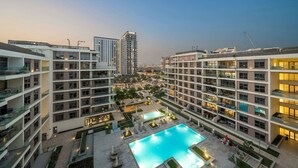 A high-rise residential building with a swimming pool and landscaped areas.