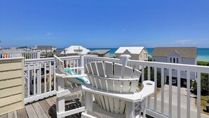 A balcony with white railings overlooking a beach with houses in the background. - 5 Bedroom home with Elevator-located in Heart of Surf City, beach access across street (Surf City)