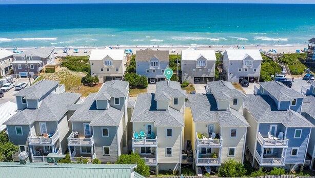 A beachfront residential area with multiple two-story houses featuring balconies and a view of the ocean. - 5 Bedroom home with Elevator-located in Heart of Surf City, beach access across street (Surf City)