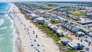 An aerial view of a coastal town with a beach, houses, and a bridge. - 5 Bedroom home with Elevator-located in Heart of Surf City, beach access across street (Surf City)