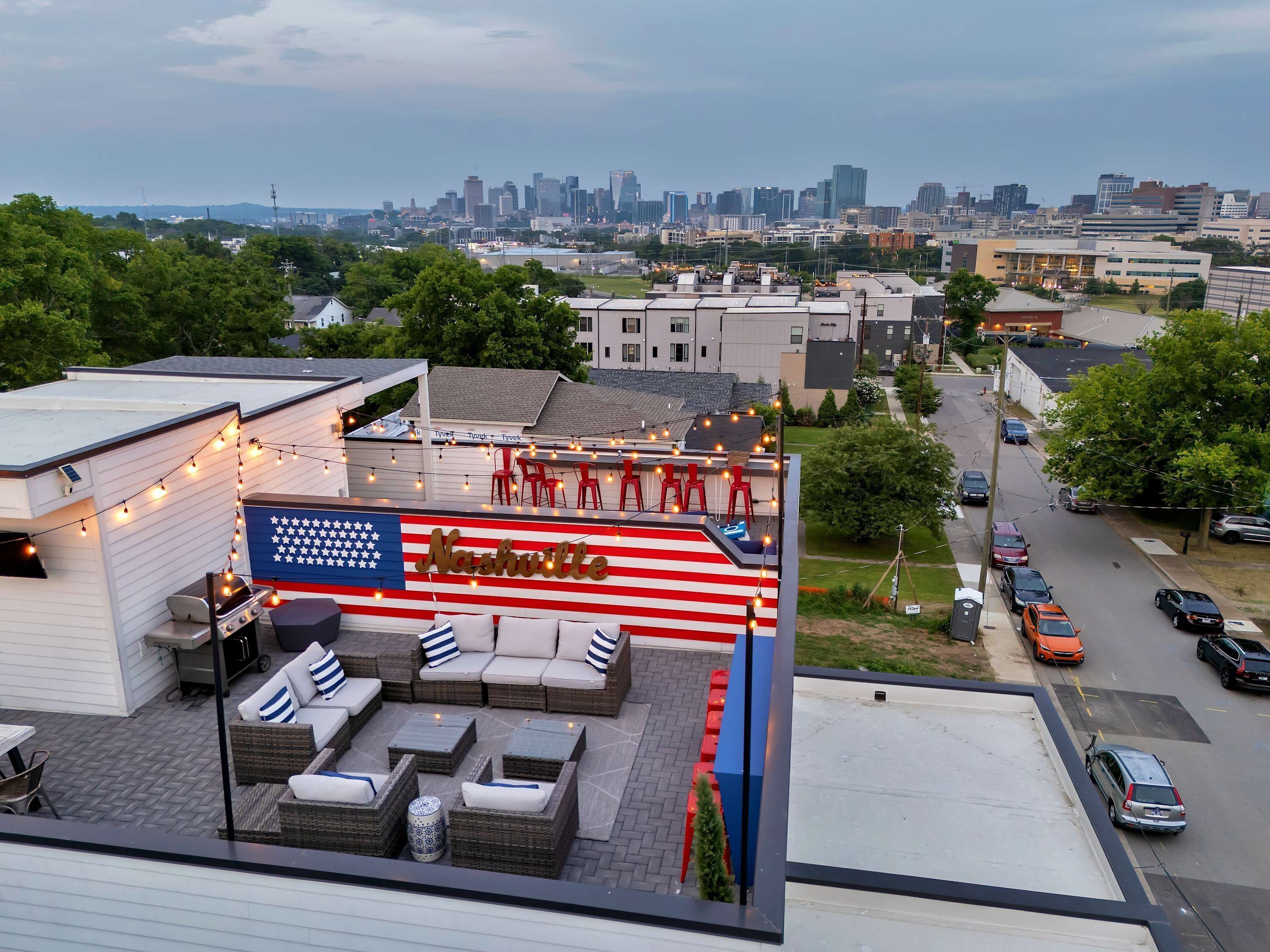 Eine Dachterrasse mit Außenbestuhlung, einer Flagge und Blick auf den Stadtpanoramahorizont.