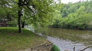 A riverside walkway with a concrete bench and steps leading to the water.