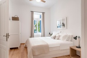 A bedroom with a bed, a nightstand, a lamp, a picture on the wall, and a window with curtains. - Athens Residence Acropolis City Views (Athens)