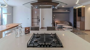 A modern kitchen with a central island, stainless steel range hood, and pendant lighting. - w Elegant 3BR w Outdoor Balcony (Medellín)