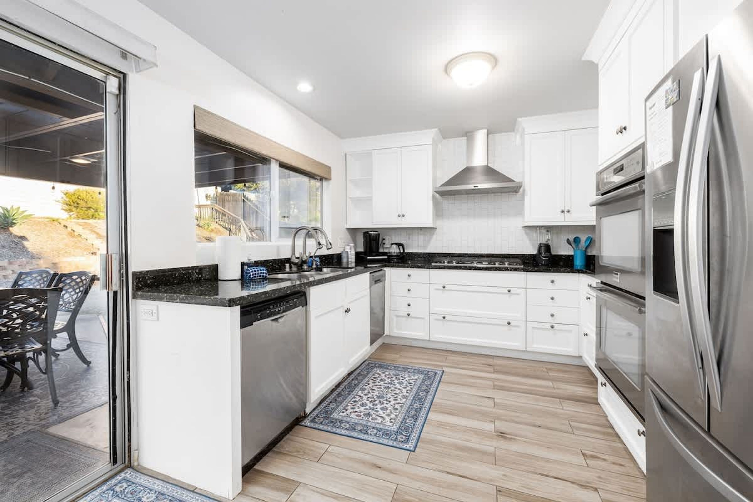 A modern kitchen with white cabinets, a stainless steel refrigerator, and a dishwasher.