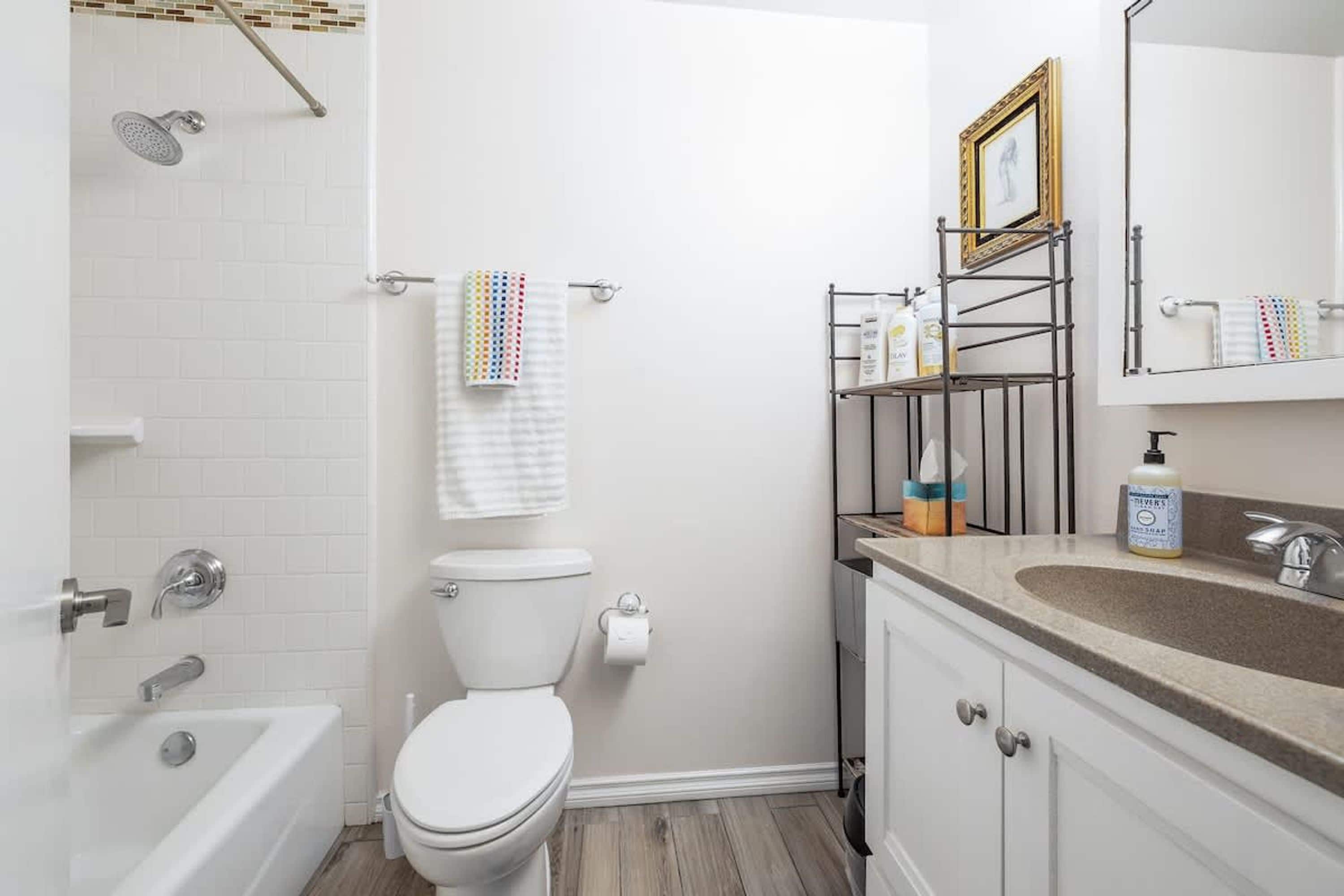 A bathroom with a bathtub, toilet, and sink.