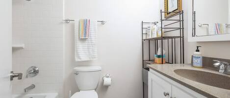 A bathroom with a bathtub, toilet, and sink.