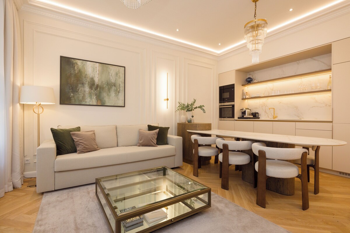 A modern living room with a sofa, coffee table, and dining area.