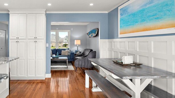 A modern kitchen with white cabinetry, a wooden dining table, and a bench. - Beautiful Home in Ocean Pines with Water Access for SUP's and Canoes (Ocean Pines)