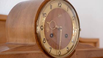 Un reloj de pie de madera con esfera circular y números romanos.