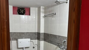 A small, compact bathroom with a toilet, bidet, and shower. - Majestic Manor (Gorakhpur)
