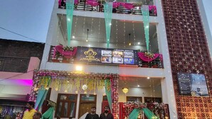 A multi-story building with balconies, a patterned carpeted entrance, and string lights. - Majestic Manor (Gorakhpur)