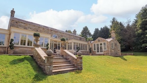 A stone building with large windows and a covered patio area.