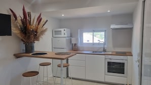A modern kitchen with white appliances, a window, and a decorative plant. - Villa Mané with swimming pool (Ollioules)