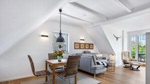Un loft moderno con comedor, sofá y sillón reclinable.
