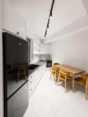 Departamento superior, balcón | Cocina privada | Refrigerador, microondas, horno y parrilla de estufa 