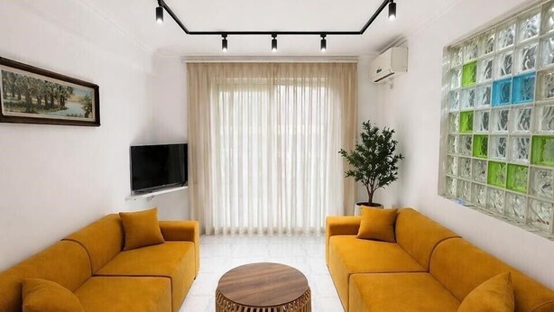 A living room with two sofas, a coffee table, a TV, and a window with curtains. - Sasori Apartments (Sarande)
