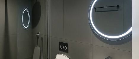 Un baño moderno con inodoro, bidé y lavabo.
