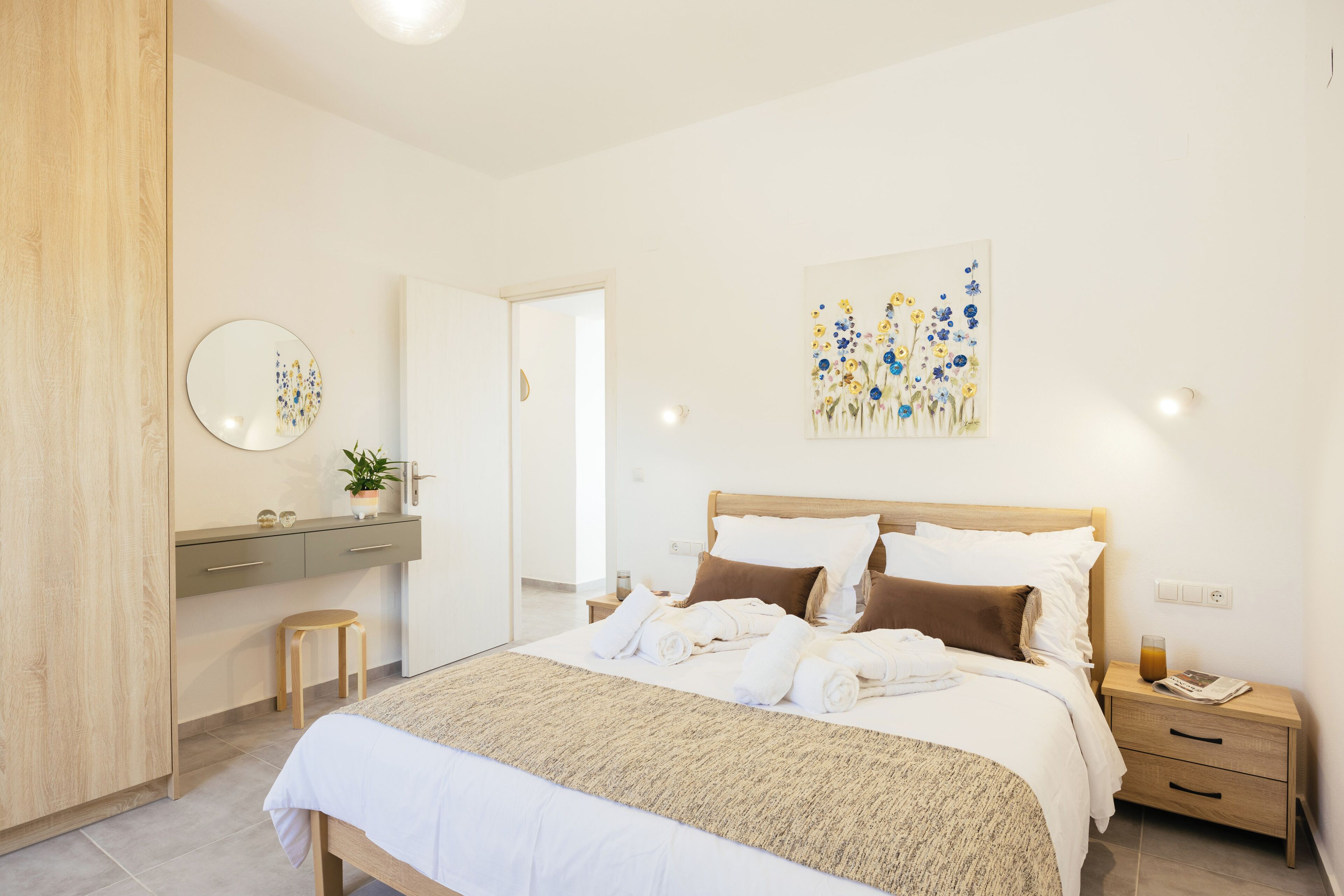 A modern bedroom with a bed, bedside table, and a nightstand.