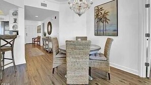 A dining area with a chandelier, round table, and chairs. - Coral Reef Unit #1304 (Beachfront 2 bedroom 2 bath condo on the 13th floor) (Panama City Beach)