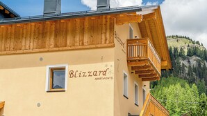 Un immeuble avec une enseigne indiquant « Blizzard Apartments » et des balcons en bois.