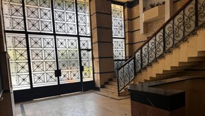 A staircase with ornate metal railings and a large glass door with a geometric pattern.