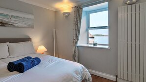 A hotel room with a bed, a window with a view, a painting on the wall, and a lamp. - Nor Nour, Cawsand (Cawsand)
