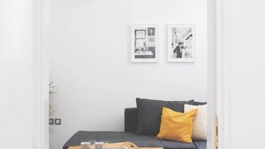 A minimalist living room with a sofa, a coffee table, and a ceiling light. - Athens Residence A1 - Cozy Nest near Acropolis (Athina)