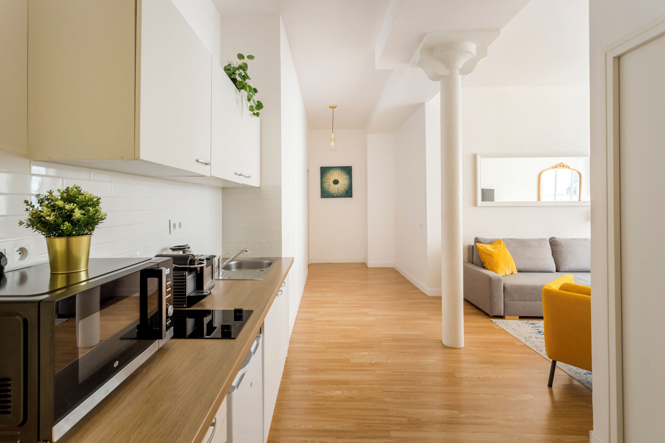 A modern kitchen with a built-in microwave and stove, a wooden countertop, and a potted plant.