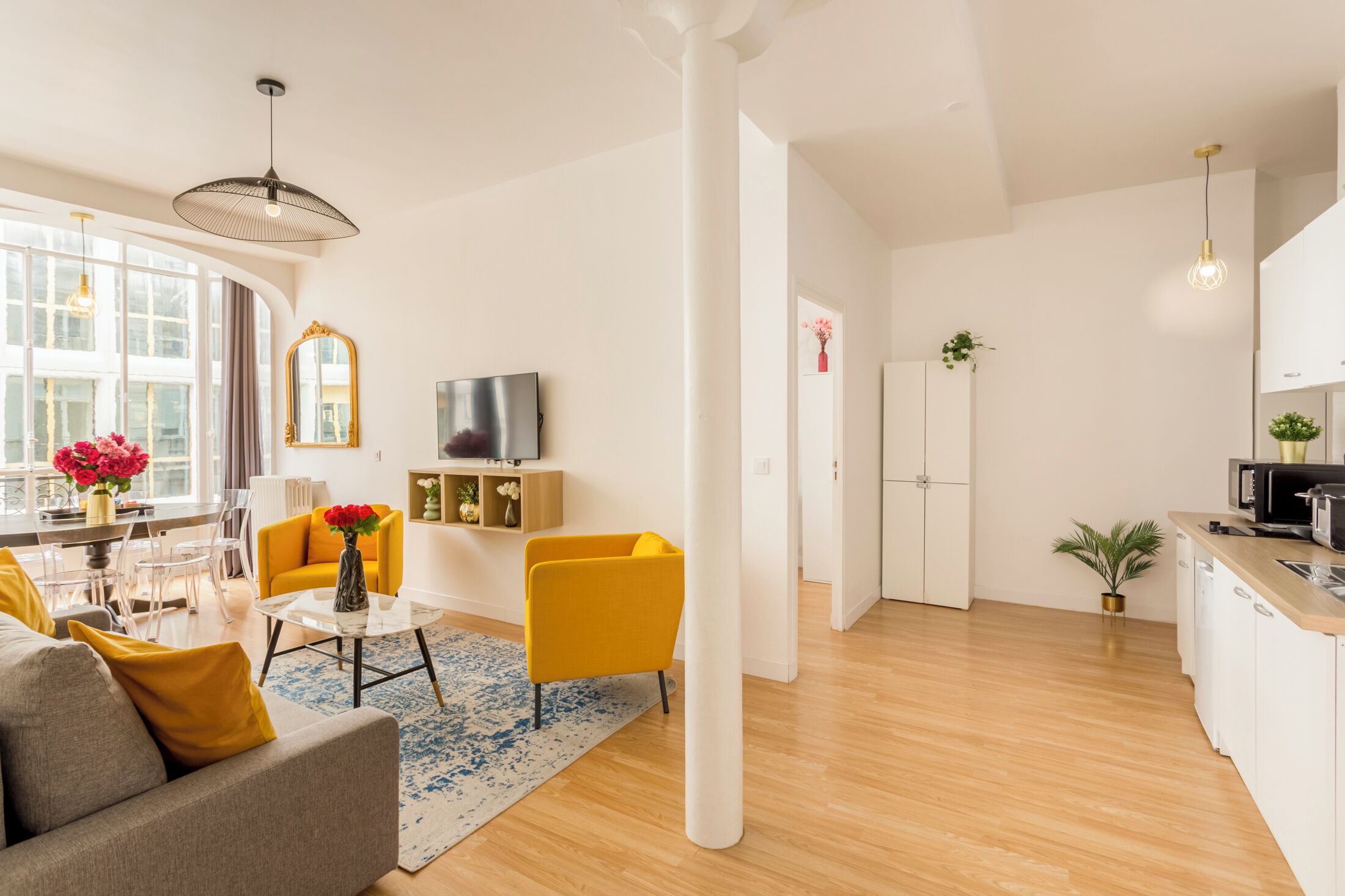 A modern apartment with a living room, dining area, and kitchen.