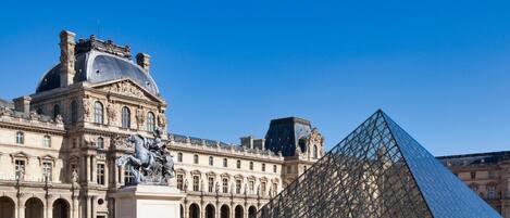A historic building with classical architecture and a large glass pyramid.