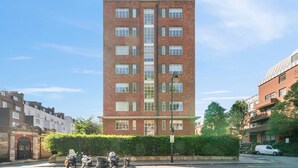 A tall brick building with multiple windows and a flat roof.