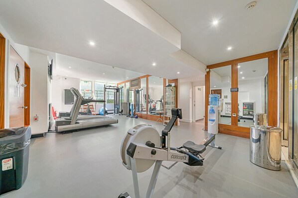 A gym with cardio machines, weight equipment, and a water dispenser.