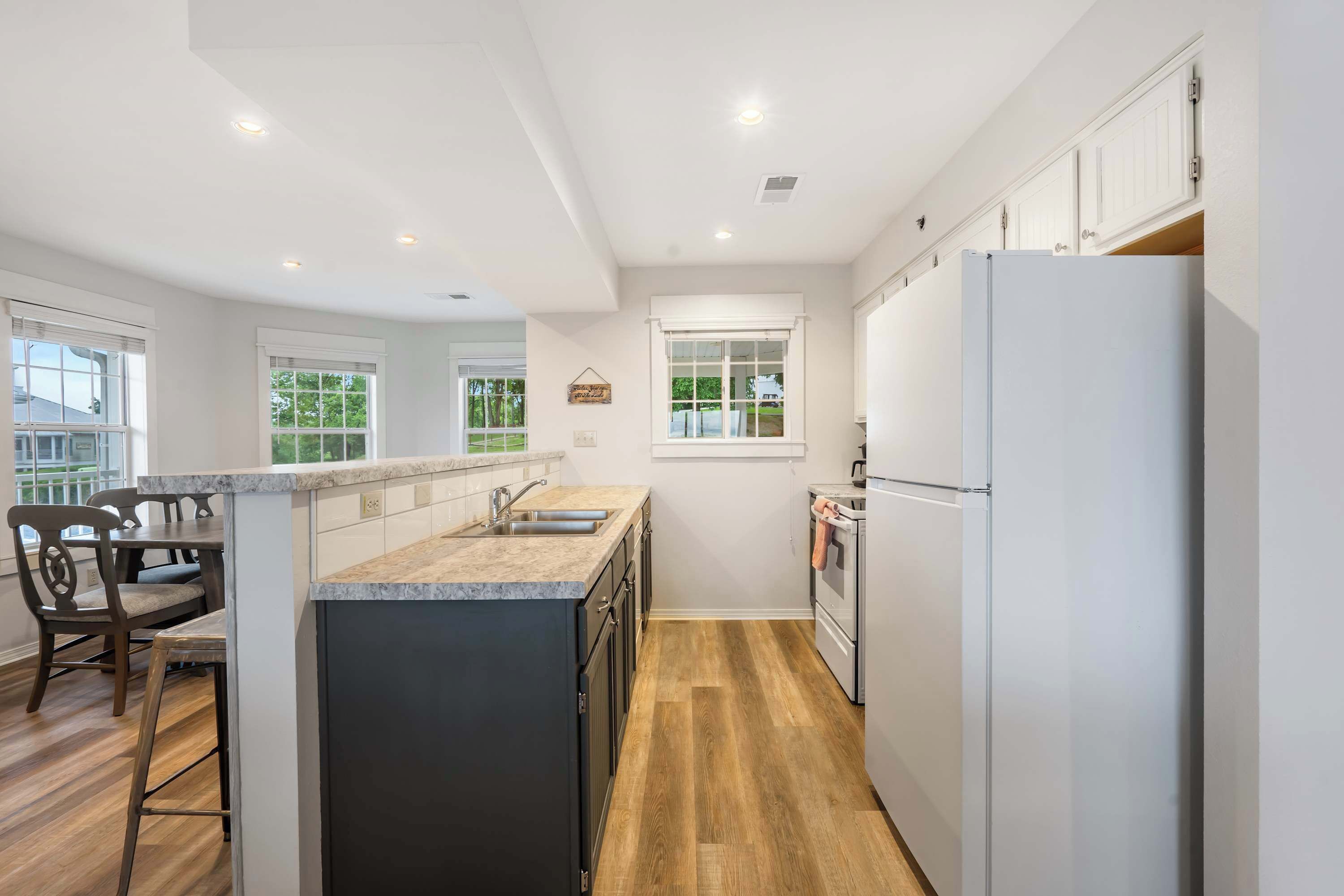A modern kitchen with a central island, built-in appliances, and a dining area with bar stools.