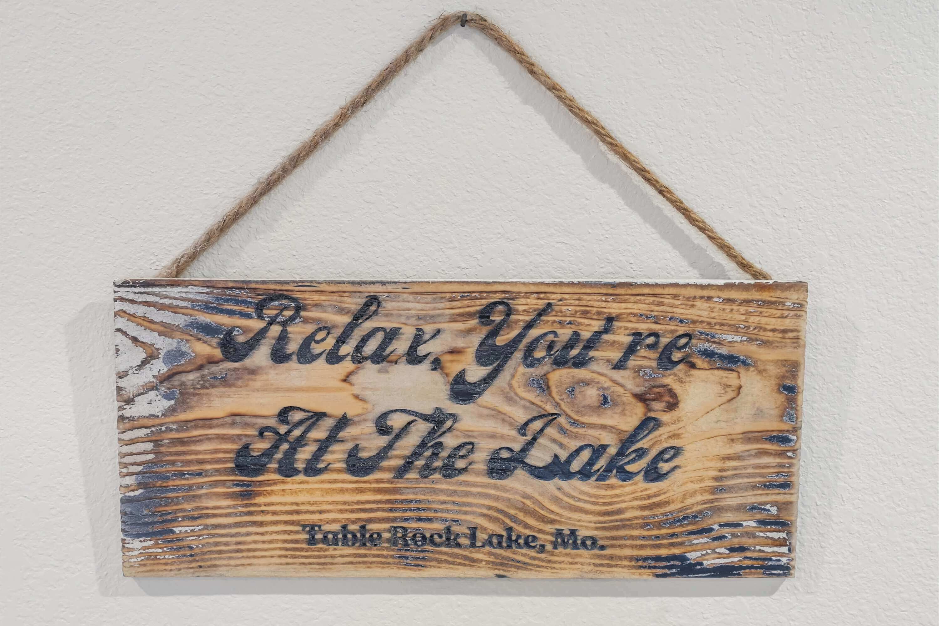 Une pancarte en bois portant l’inscription « Détendez-vous, vous êtes au bord du lac » et « Table Rock Lake, Missouri ».