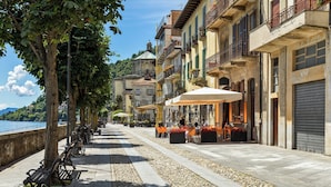 A waterfront promenade with outdoor seating, a row of bicycles, and buildings with balconies. - L' Angolino di Cannobio: Stone Home for 4 With Terrace (Cannobio)