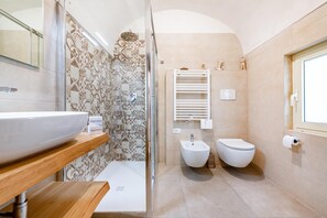 Une salle de bain moderne avec un grand lavabo blanc, une douche et des toilettes.