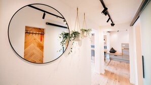 A hallway with a round mirror, wooden flooring, hanging plants, and recessed lighting. - Apartment 'Fewo Tauberblick' with Shared Terrace, Private Garden and Wi-Fi (Röttingen)