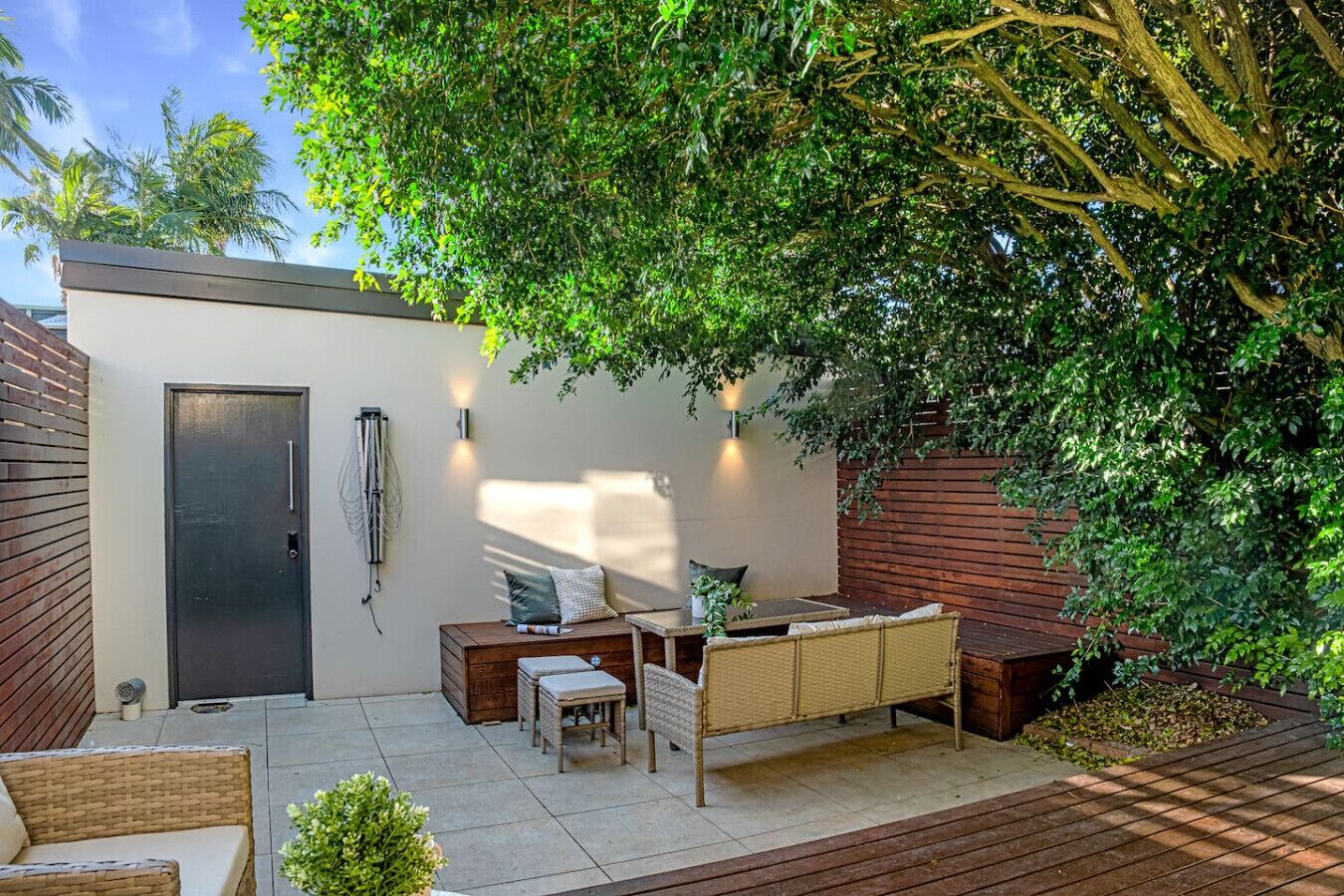 A modern outdoor patio with a sofa, table, and chairs.