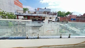 A rooftop terrace with a metal railing, a water feature, and a view of surrounding buildings. - Hotel Kashi Vaas (Varanasi)