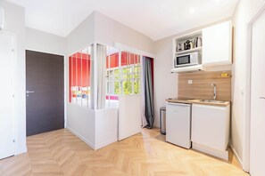 A compact kitchen with a microwave, sink, and small refrigerator.
