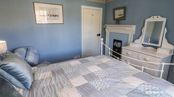 Un dormitorio con cama, cómoda, espejo y puerta.