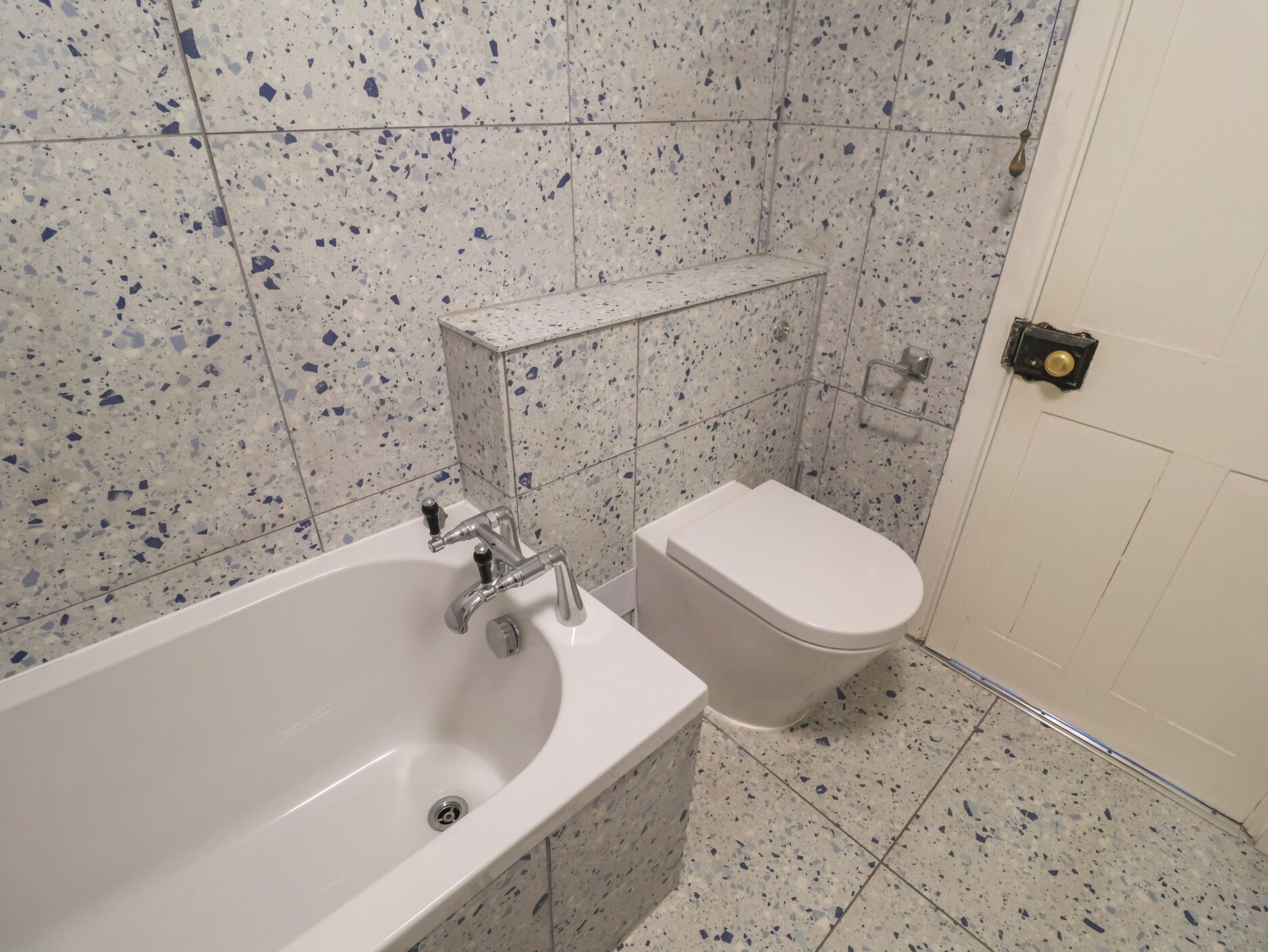 Ein Badezimmer mit Badewanne, Toilette und Duschbereich.