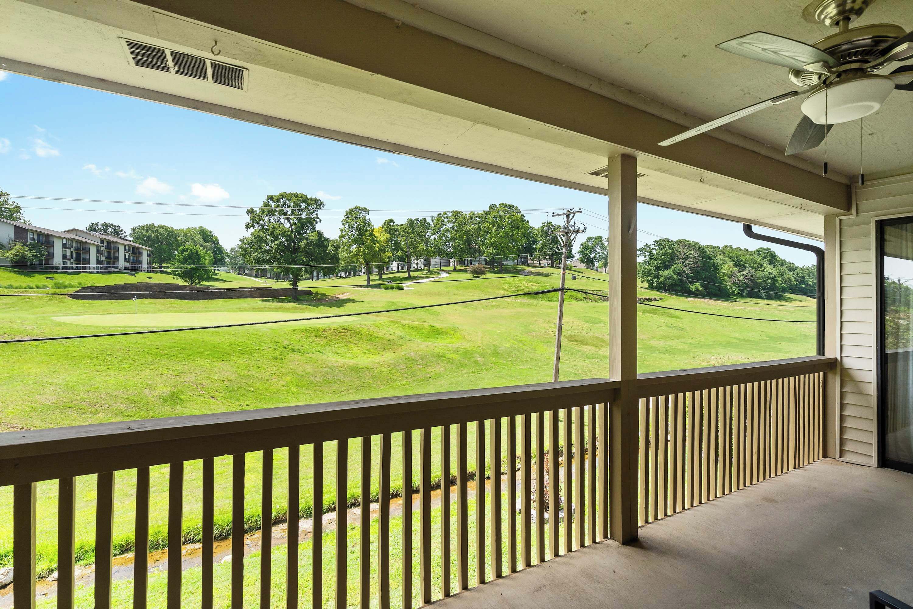 A balcony with a view of a golf course.