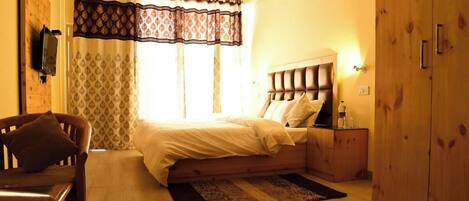 Un dormitorio con cama, armario de madera, mesita de noche y una silla.