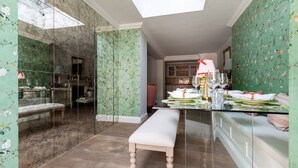A modern room with a glass table, a bench, and a skylight. - Westbourne Park Road Xvii by Onefinestay (London)