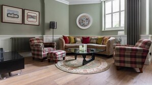 A living room with a sofa, armchairs, a coffee table, and a radiator. - Drury Lane II by Onefinestay (London)