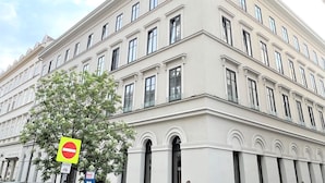 A large, multi-story building with a classical architectural style, featuring symmetrical windows and a prominent entrance with an arched doorway.