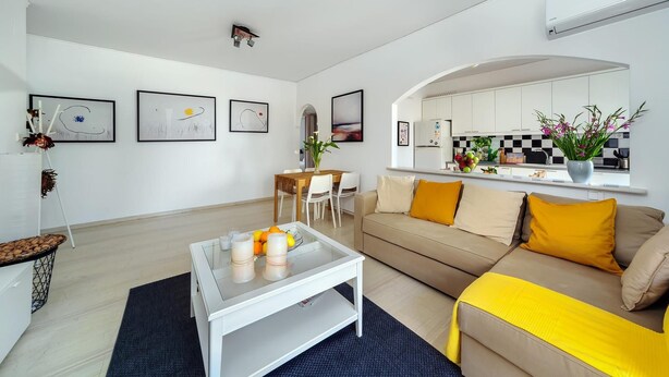 Ein modernes Wohnzimmer mit einer Couch, einem Couchtisch und Kunstwerken an den Wänden.