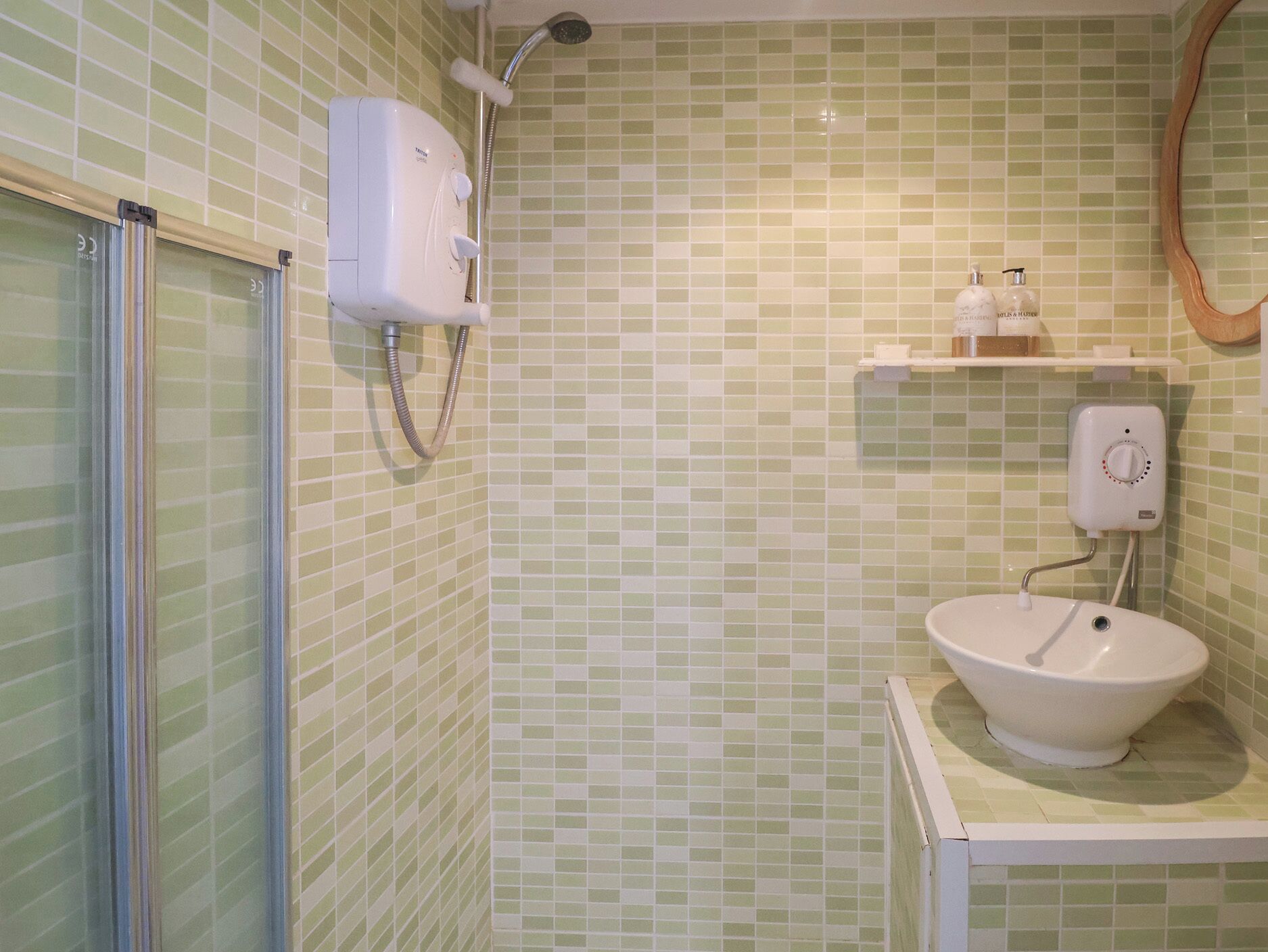 A bathroom with a shower, a sink, and a mirror.